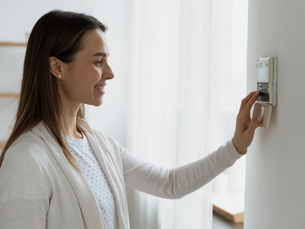 Une femme qui règle son thermostat